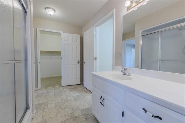 bathroom with a shower with shower door and vanity