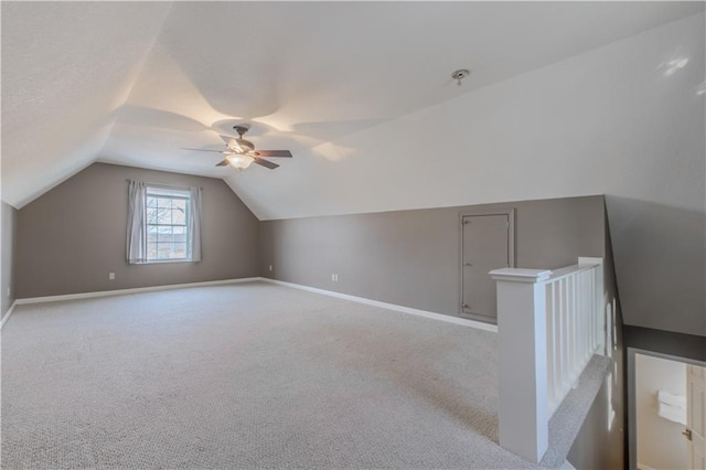 additional living space with vaulted ceiling, ceiling fan, and light colored carpet