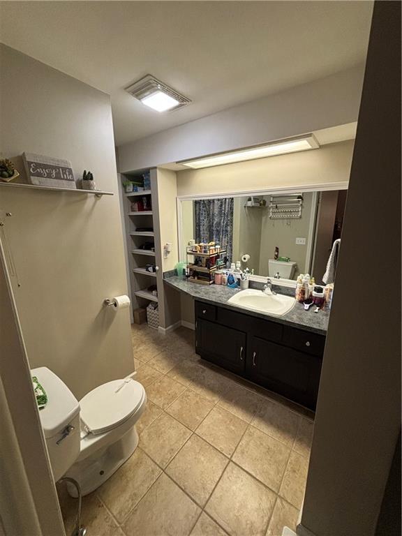 bathroom featuring tile patterned flooring, vanity, and toilet