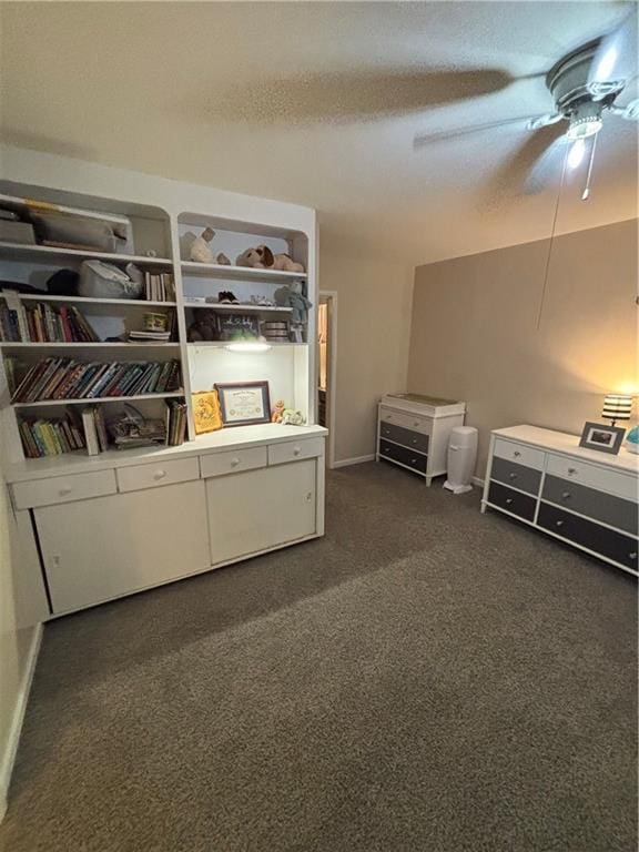 interior space featuring ceiling fan, dark carpet, and a textured ceiling