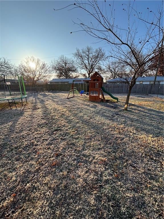 view of yard featuring a trampoline and a playground