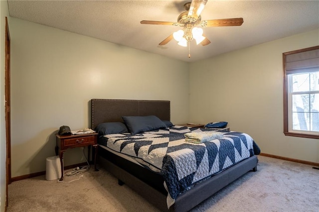 carpeted bedroom featuring ceiling fan and a textured ceiling