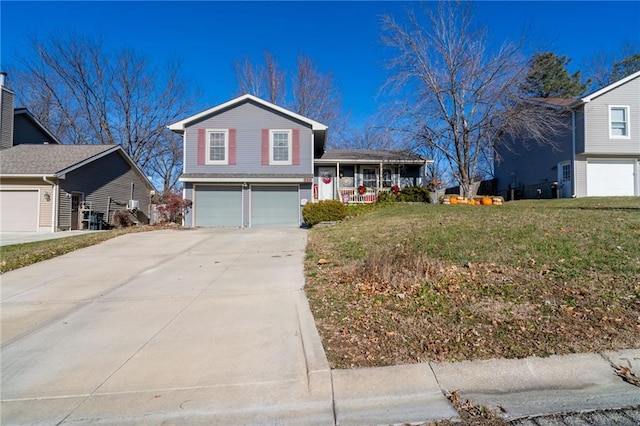 split level home featuring a front yard, a garage, and covered porch