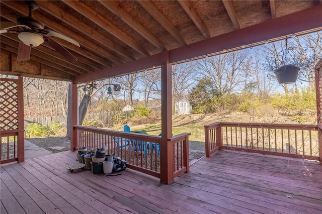 wooden terrace with ceiling fan and a storage shed