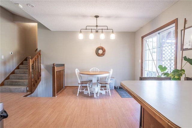 dining room with light hardwood / wood-style floors and a textured ceiling