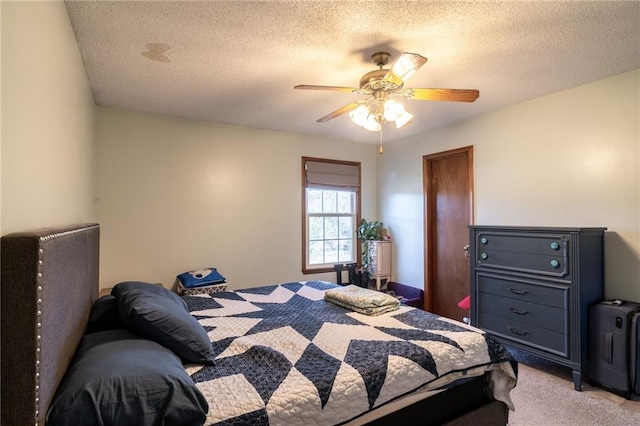 bedroom with a textured ceiling, ceiling fan, and light carpet