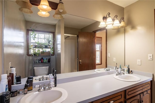 bathroom featuring vanity, toilet, and a shower with door