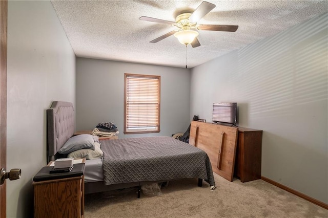 bedroom featuring ceiling fan, light carpet, and a textured ceiling