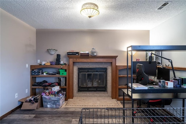 living room featuring a tiled fireplace and a textured ceiling