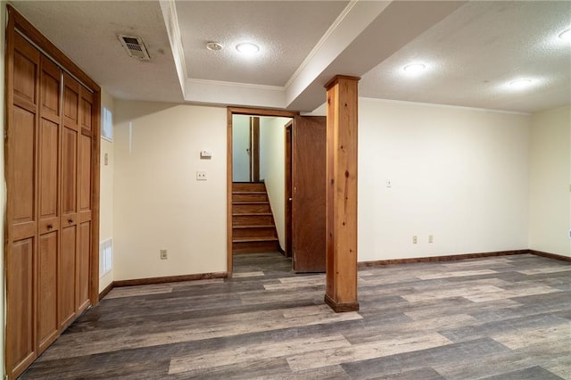 basement with crown molding, a textured ceiling, and dark wood-type flooring