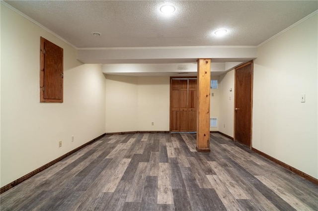 basement featuring a textured ceiling, dark hardwood / wood-style floors, and ornamental molding