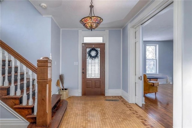 foyer featuring light wood-type flooring and ornamental molding