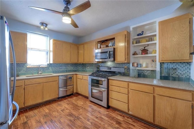 kitchen with sink, light brown cabinets, ceiling fan, light hardwood / wood-style floors, and appliances with stainless steel finishes