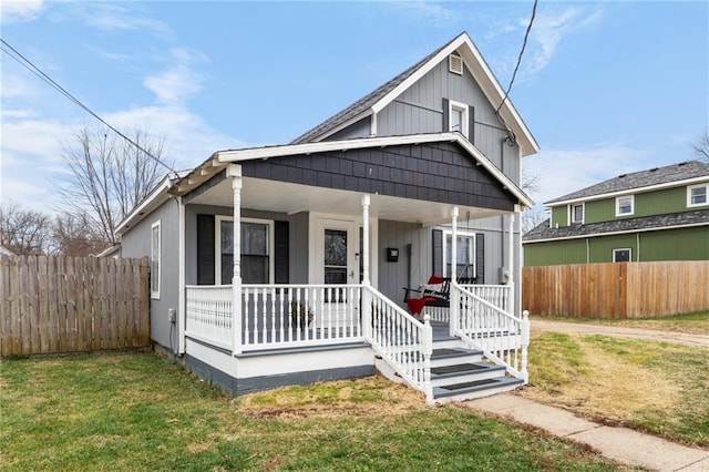 bungalow-style house featuring covered porch and a front lawn