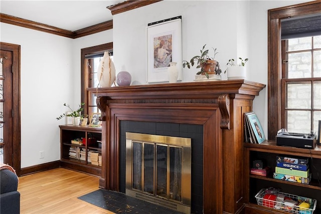 interior space with crown molding, a tile fireplace, and hardwood / wood-style flooring