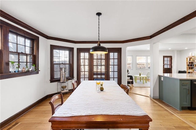 dining space featuring crown molding and light wood-type flooring