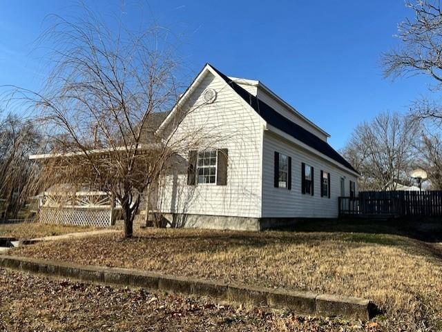 view of side of home featuring a yard and a deck