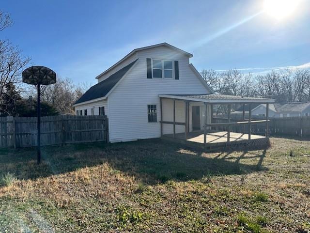 back of house featuring a patio, a sunroom, and a lawn