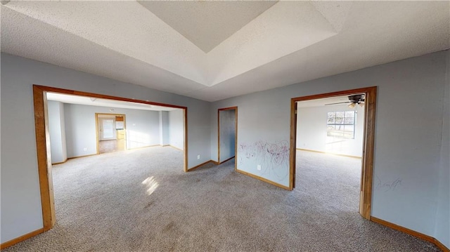 spare room featuring a textured ceiling, ceiling fan, and light carpet