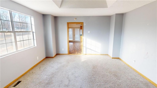 empty room featuring carpet flooring and french doors