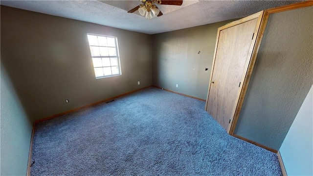 carpeted empty room with a textured ceiling and ceiling fan