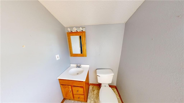 bathroom with toilet, a textured ceiling, vanity, and vaulted ceiling