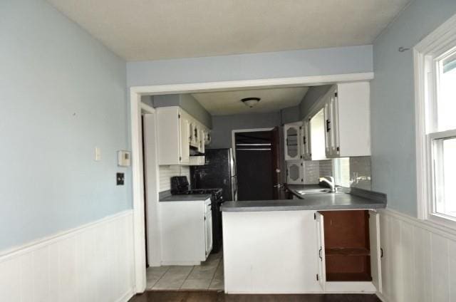 kitchen featuring tasteful backsplash, white cabinetry, plenty of natural light, and sink