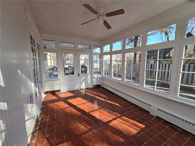 unfurnished sunroom featuring a wealth of natural light, ceiling fan, and a baseboard radiator