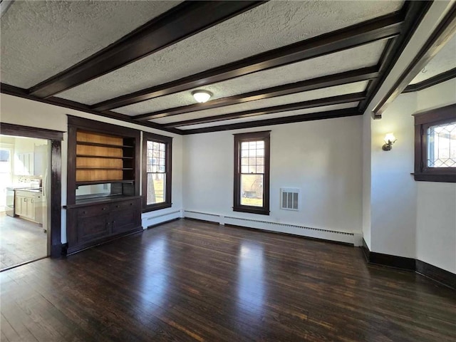 unfurnished living room featuring beam ceiling, dark wood-type flooring, built in features, a baseboard heating unit, and a textured ceiling