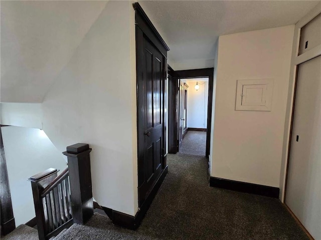 hall featuring dark colored carpet