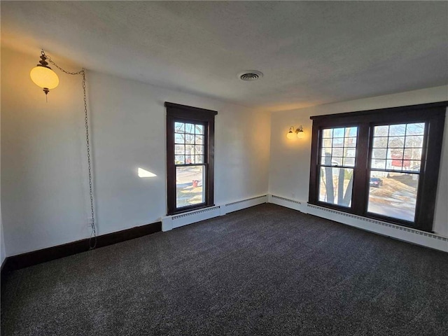 carpeted spare room featuring baseboard heating and a textured ceiling