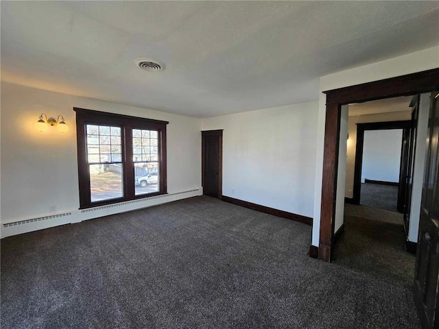 spare room featuring a baseboard radiator and dark colored carpet