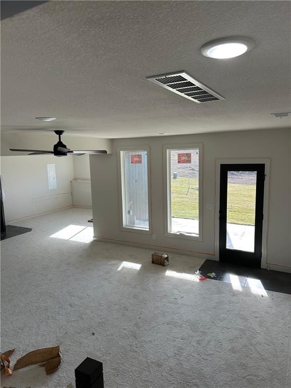 unfurnished room with ceiling fan, carpet, and a textured ceiling