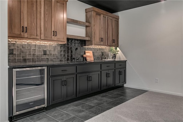 kitchen featuring sink, beverage cooler, dark colored carpet, tasteful backsplash, and gray cabinets