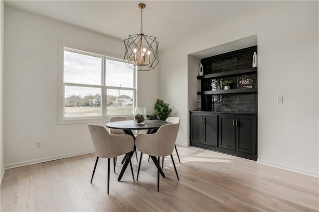 dining space with a notable chandelier and light hardwood / wood-style flooring