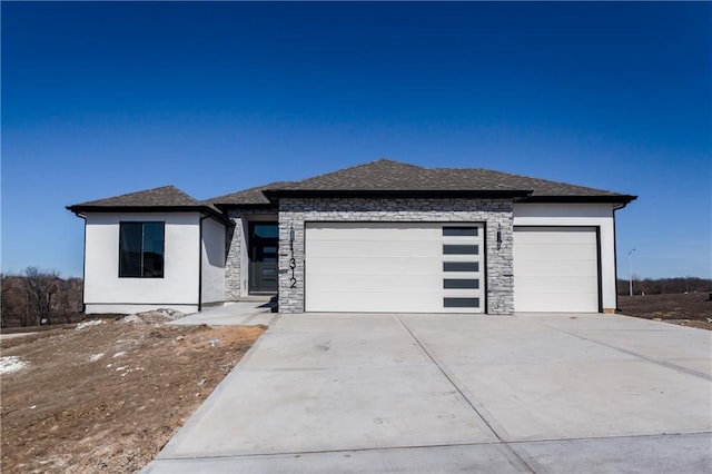 prairie-style home featuring concrete driveway, roof with shingles, stucco siding, stone siding, and an attached garage