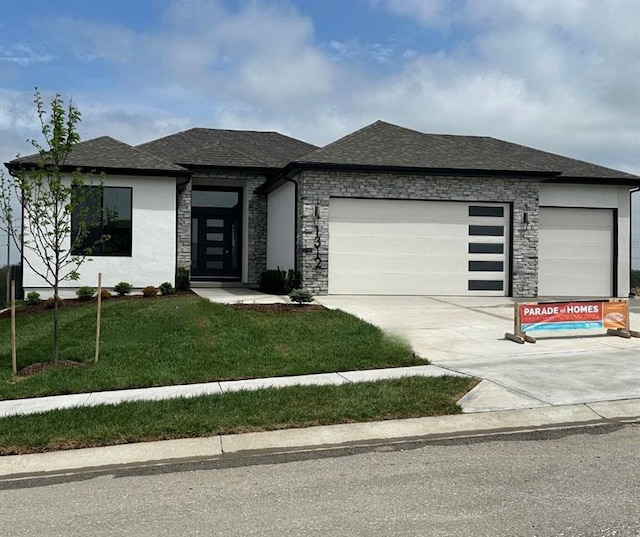 1312 Verbena Pl, Raymore, MO 64083 - prairie-style home featuring a garage, concrete driveway, roof with shingles, and a front yard