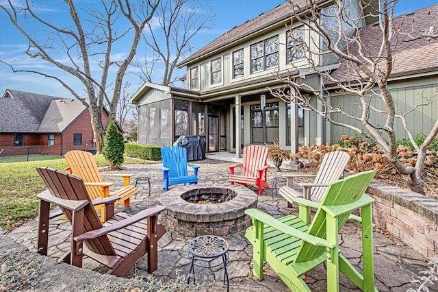 view of patio featuring grilling area, an outdoor fire pit, and a sunroom