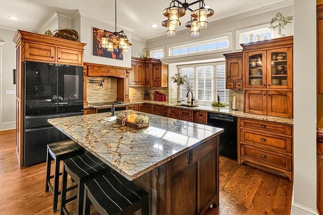 kitchen featuring a kitchen island, black appliances, dark hardwood / wood-style floors, and a notable chandelier