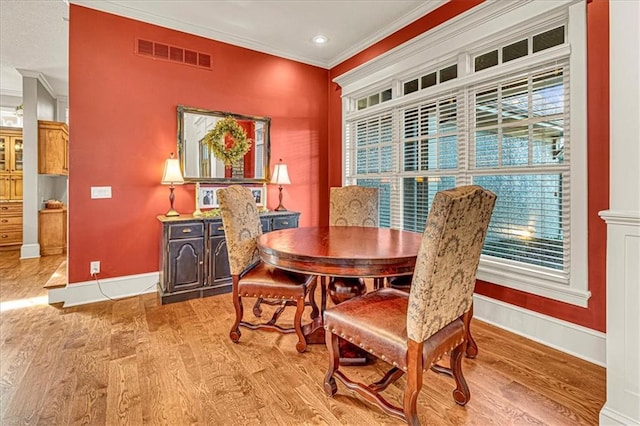 dining room featuring light wood-type flooring and ornamental molding