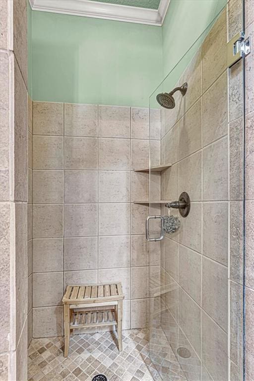 bathroom featuring a shower with shower door and ornamental molding