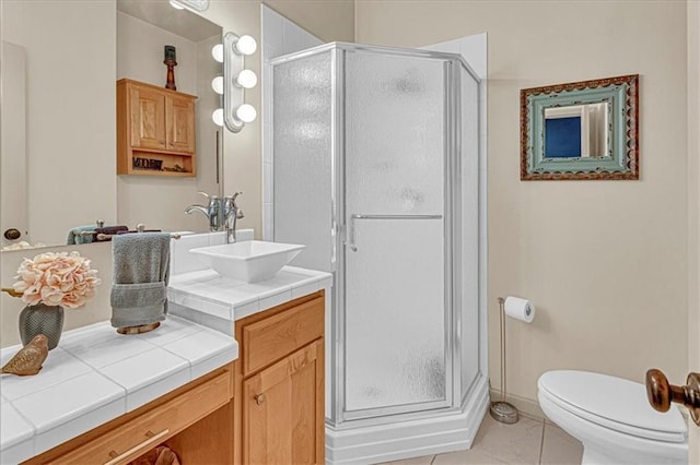 bathroom with tile patterned flooring, vanity, toilet, and walk in shower