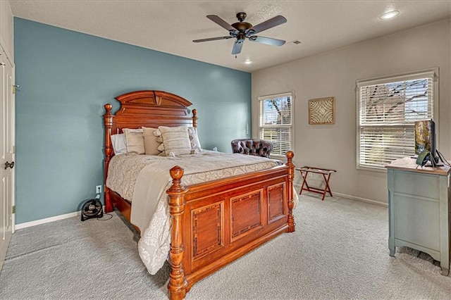 bedroom featuring ceiling fan, light colored carpet, and multiple windows