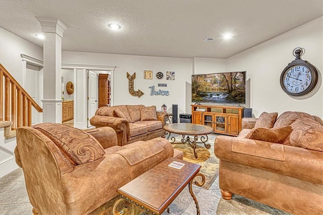 living room featuring decorative columns and a textured ceiling