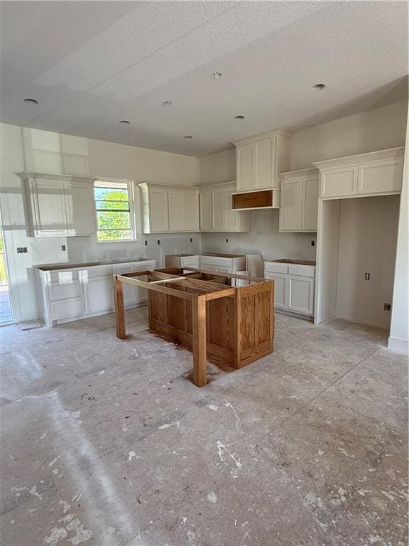 12749 NE Seminole Rd, Adrian, MO 64720 - kitchen featuring a textured ceiling and white cabinetry