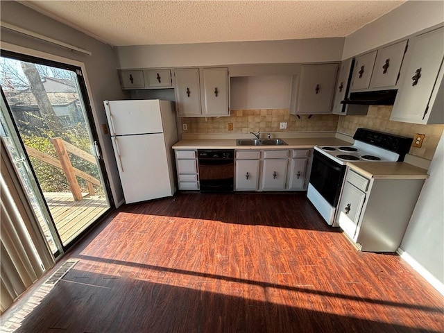 kitchen with decorative backsplash, white appliances, dark hardwood / wood-style floors, and sink