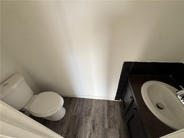 bathroom with wood-type flooring, vanity, and toilet