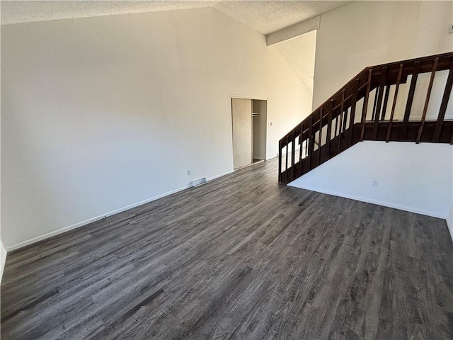 interior space with dark hardwood / wood-style flooring, lofted ceiling, and a textured ceiling