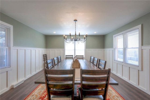 dining area with dark hardwood / wood-style floors and a chandelier