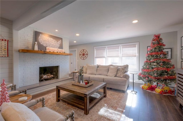 living room with wood-type flooring and a brick fireplace